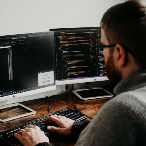 Mann am Computer, der mit einer Programmiersoftware arbeitet